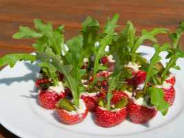 Teller mit gefüllten Erdbeeren mit Rucola, Parmesan und Spargel als Fingerfood