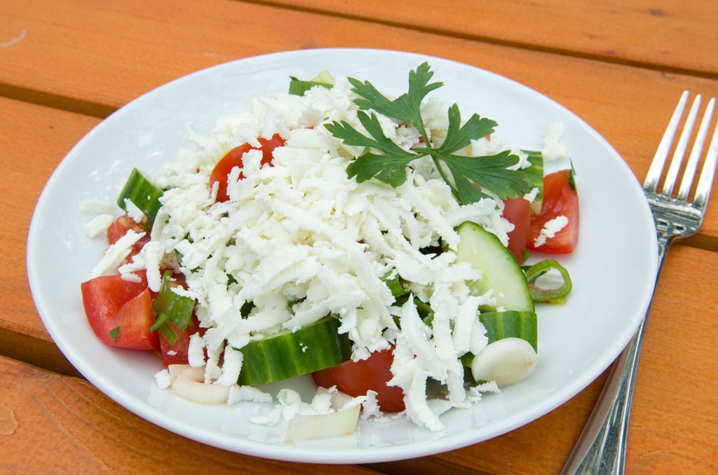Teller mit echtem Schopskasalat aus Bulgarien mit Gurken, Tomaten und Schafskäse
